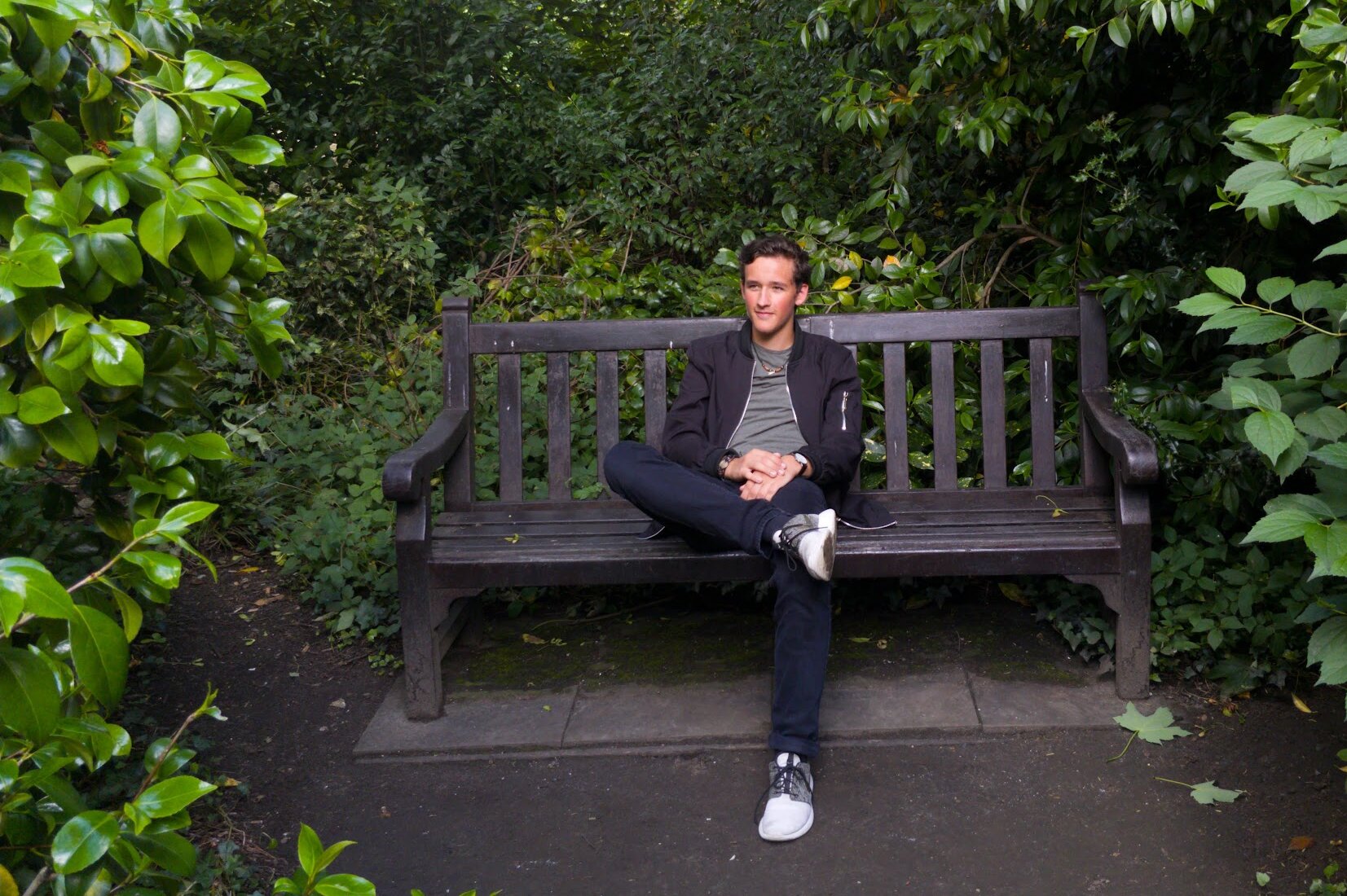 Dylan Kuzmick sitting on a bench in a garden